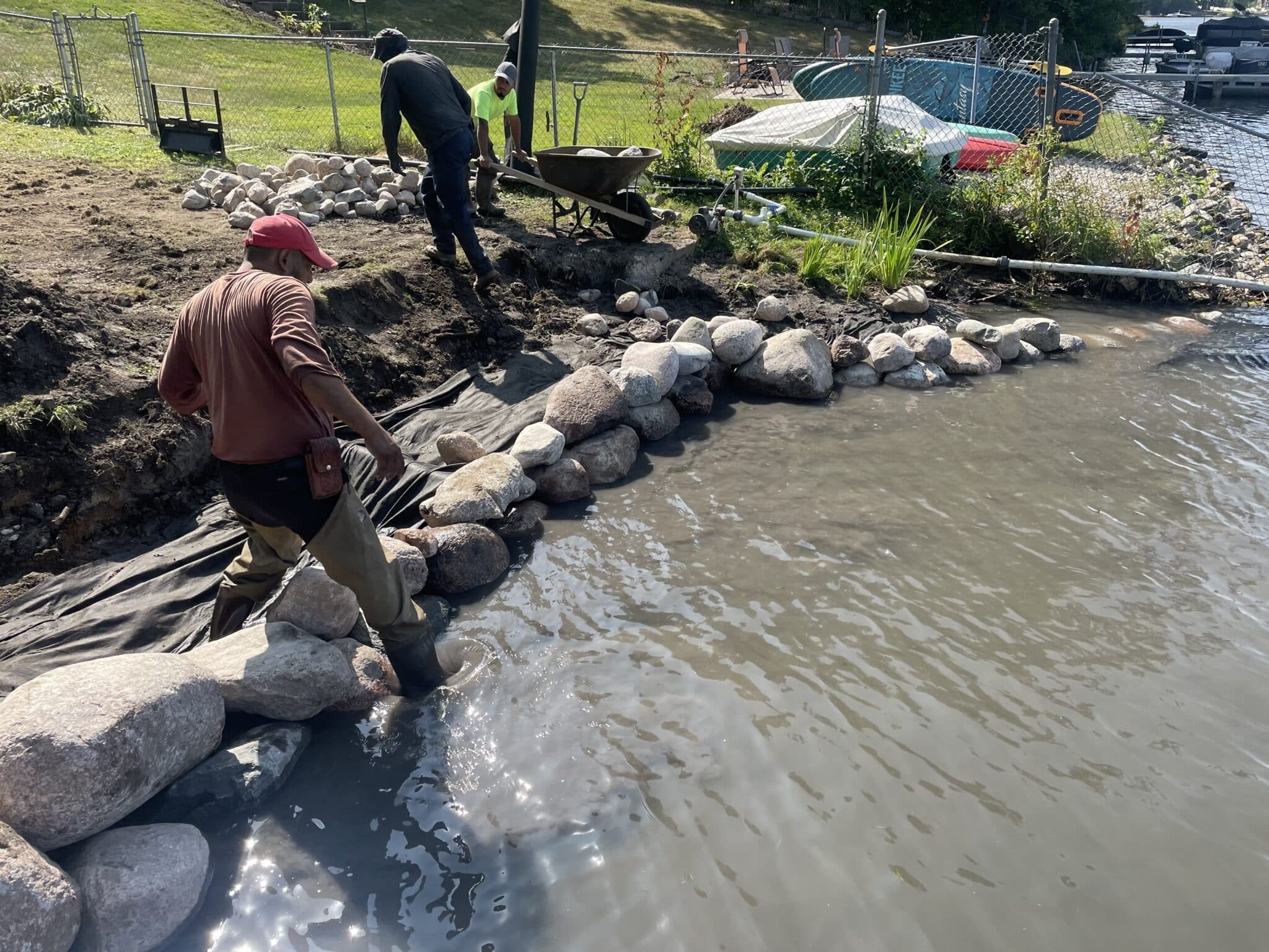 Crew setting boulders along an eroding shoreline